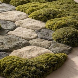 May include: A textured rug with a stone-like design. The rug features a pattern of various-sized, rounded shapes in shades of green, gray, and beige. The rug's design resembles a pathway or stepping stones, adding a natural element to the space.