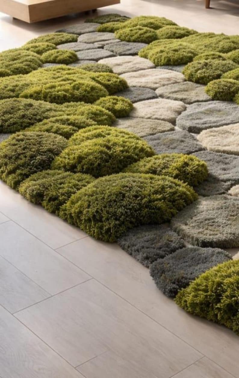 May include: A unique area rug with a textured design resembling stepping stones. The rug features a mix of green, gray, and beige tones, creating a natural, organic aesthetic. The plush, soft texture adds visual interest and comfort to any room.