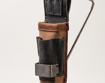 May include: A leather tool belt in black and brown, with multiple pockets and a metal clip. The belt is designed to be hung from a metal bar. The tool belt is made of leather and suede.