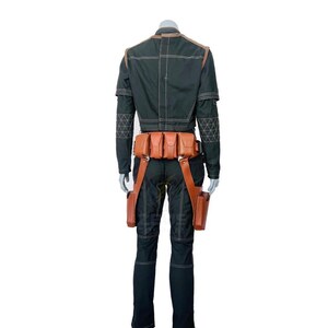 K&ouml;nnte beinhalten: Schwarzer Overall mit braunen Lederakzenten, einschlie&szlig;lich eines G&uuml;rtels mit Taschen und Beintaschen. Das Outfit hat geometrische N&auml;hte und wird auf einer Schaufensterpuppe pr&auml;sentiert. Ideal f&uuml;r Cosplay oder Mottopartys.