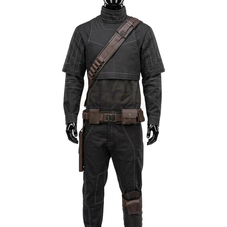May include: A black long-sleeved shirt and matching pants set featuring white contrast stitching. The outfit includes a brown leather-like shoulder strap with ammunition loops, a utility belt with attached pouches, and a leg holster accessory.