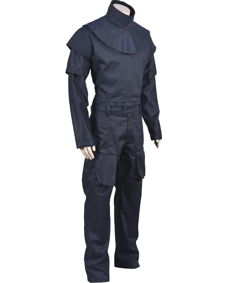 May include: A dark navy blue uniform set consisting of a high-neck top with a structured shoulder yoke and long sleeves, paired with matching trousers featuring large, prominent cargo-style pockets on the thighs, displayed on a mannequin.