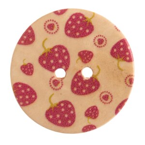 May include: A round, light-coloured wooden button featuring a repeating pattern of small, dark pink strawberries with green stems and white dots. The button has two circular holes positioned in the centre for attachment to fabric or garments.
