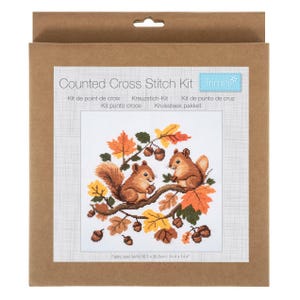 May include: A Trimits counted cross stitch kit in a brown cardboard box. The label features two brown squirrels on a tree branch surrounded by orange, yellow, and brown autumn leaves and acorns. The fabric size is listed as 36.5 x 36.5 cm.