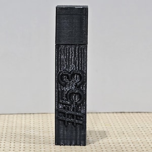May include: A black, rectangular USB drive with a textured surface. The drive features the embossed text "30C#" on its front. The top of the drive is a solid, flat rectangle. The background is a light beige surface.