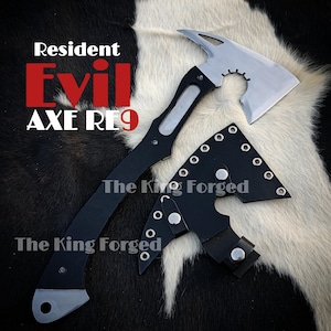Pode incluir: Um machado preto e prateado com o texto "Resident Evil AXE RL9" e "The King Forged". O machado tem um cabo preto e uma lâmina prateada com um design único em forma de engrenagem. Uma bainha de couro preta também está incluída.
