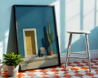 May include: A framed art print featuring a yellow door, cactus, and a small striped chair against a teal wall. A potted plant and a white stool are in the foreground. The floor has a red and white checkered pattern.