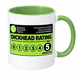 Può includere: Una tazza in ceramica bianca con interno e manico verde lime. La parte anteriore presenta un'etichetta nera e verde lime con il testo Dickhead Standards Agency, This scheme has certified that you are indeed an absolute Dickhead, e DICKHEAD RATING con una scala da 0 a 5, evidenziando il numero 5 come Absolute.