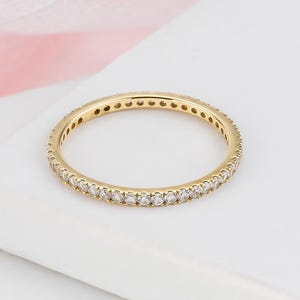 May include: A white ceramic mug with a black handle and the text "But First, Coffee" in a black, handwritten-style font. The mug is on a white surface.