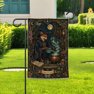 Peut inclure: Un drapeau de jardin rectangulaire représentant un renard vêtu d'une robe et d'un chapeau de sorcier bleu foncé, versant un liquide bleu brillant d'une fiole dans un chaudron en cuivre. On y voit un livre ouvert, des champignons et le texte LUMEN IN SILVIS.