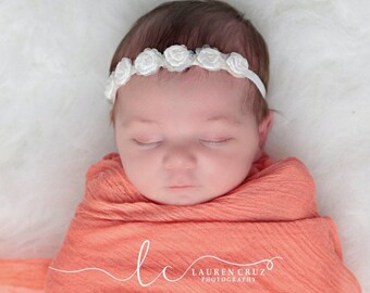 Newborn Headband with Irridescent sequins surrounding white satin roses on white soft stretch elastic by Lil Miss Sweet Pea