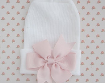 White Newborn Hospital Hat with a light pink pinwheel ribbon pearl bow, baby hat, perfect baby shower gift, from Lil Miss Sweet Pea Boutique