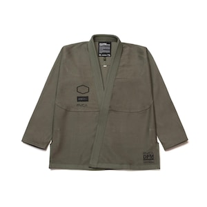 May include: Olive green martial arts gi with a wrap-around design. The jacket features a geometric patch and the brand name "RVCA" printed on the front and lower right. The gi has a textured weave and a label with text at the top.
