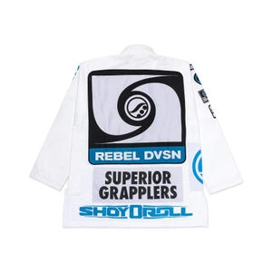 May include: White martial arts uniform with black and blue graphics. The back features a large design with the text "REBEL DVSN", "SUPERIOR GRAPPLERS", and "SHOYOROLL". The uniform has long sleeves and is designed for grappling.