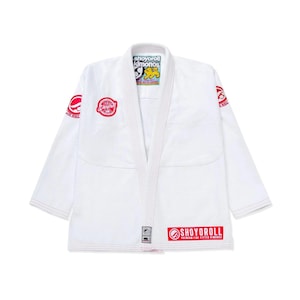 May include: White Jiu-Jitsu gi with red and black logos. The gi features the words "SHOYOROLL KIMONOS" on the collar and "SHOYOROLL PREMIUM FINE FITTED KIMONOS" at the bottom. The gi has a V-neck design.