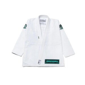 May include: White martial arts gi with the text "SHOYOROLL" in a teal rectangle on the lower right. A teal and black logo is on the left shoulder. The uniform is a traditional gi, with a lapel and long sleeves.