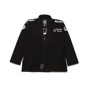 May include: Black Jiu-Jitsu gi with white text and logos. The gi features the text "IN GUARD WE TRUST" on the right side and "OYO ROLL" on the left shoulder. The gi has a traditional collar and reinforced stitching.