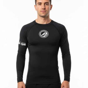 May include: Black long-sleeve compression shirt with a crew neck. A white circular logo is on the chest, and the text "e.que" is on the left sleeve. The shirt is form-fitting and appears to be made of a moisture-wicking material.