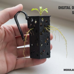 May include: A black modular hydroponic planter with a small plant growing inside. The planter has a handle and water droplet-shaped cutouts. Text on the image reads "DIGITAL DOWNLOAD STL" and "MODULAR STRUCTURE".