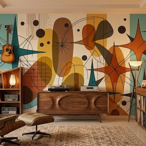 May include: A room featuring a large wall mural with abstract shapes, starbursts, and circles in teal, orange, and brown. The space includes a wooden bookshelf, a walnut sideboard with a record player, a lounge chair with an ottoman, and a vinyl record storage unit.