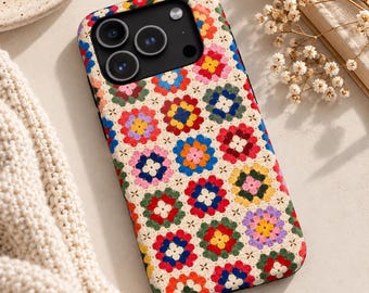 May include: A smartphone case featuring a repeating granny square crochet pattern in vibrant colors including red, blue, yellow, green, and pink on a cream background. The case has a black camera cutout area with three lenses.