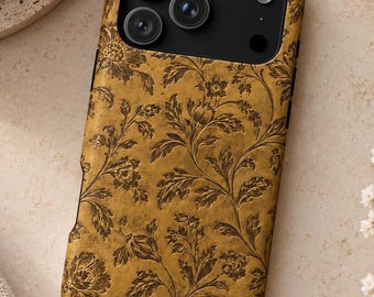 May include: A rectangular smartphone case featuring a mustard yellow background with a dark brown embossed floral pattern. The case has a black camera module cutout at the top, revealing three circular camera lenses and a flash.