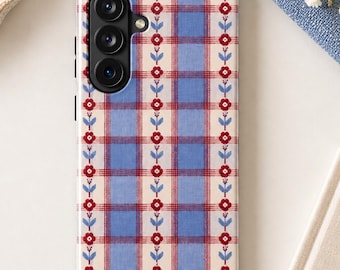 May include: A rectangular smartphone case featuring a light blue and cream plaid pattern overlaid with vertical rows of small red flowers and blue leaves. The case has a black camera module with three circular lenses on the upper left side.