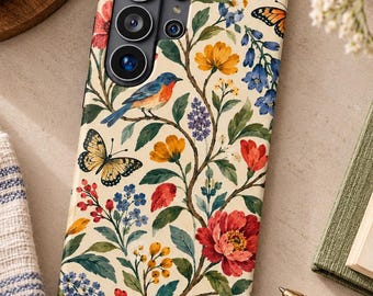 May include: A cream-colored phone case featuring a botanical pattern with red, yellow, and blue flowers, green leaves, a blue bird perched on a branch, and two butterflies with orange and yellow wings, surrounding the camera lens array.