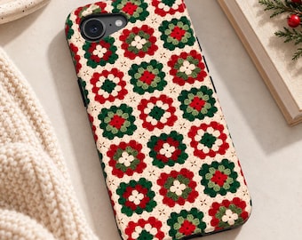 May include: A rectangular phone case featuring a repeating pattern of crocheted granny squares in shades of red, dark green, and cream. The design mimics a textured knit fabric with a central camera cutout at the top left corner of the case.