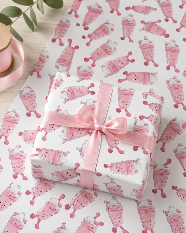 May include: A wrapped gift with a pink satin ribbon and bow, placed on a sheet of matching wrapping paper. The wrapping paper features a repeating pattern of pink milkshake characters with smiling faces on a white background.