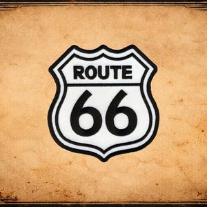 May include: A Route 66 sign in black and white, with the words "ROUTE 66" above the number "66". The sign is set against a tan background with a decorative border.