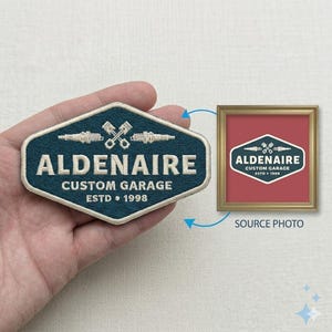 May include: A teal and white embroidered patch with the text "ALDENAIRE CUSTOM GARAGE ESTD 1998" and a graphic of crossed pistons and spark plugs. A framed image of the patch is shown next to the patch.