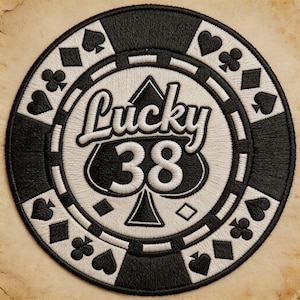 May include: Embroidered patch in the shape of a casino chip. The chip is black and white, with the words "Lucky 38" in white script. The number "38" is below the word "Lucky". The chip has suit symbols around the edge.