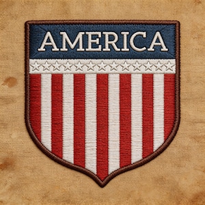 May include: Embroidered patch in a shield shape, featuring the word "AMERICA" in white capital letters on a blue background. Below, a row of white stars and red and white vertical stripes complete the design. The patch has a brown border.