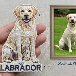 May include: Embroidered patch featuring a sitting Labrador Retriever dog with a smiling expression. The patch has a cream and tan color scheme with the word "LABRADOR" in blue lettering at the bottom. A framed photo of the dog is also shown.