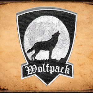 May include: A black and white embroidered patch featuring a howling wolf silhouette against a full moon. The patch is shield-shaped with the word "Wolfpack" in a gothic font at the bottom. The background is a textured, sepia-toned paper.