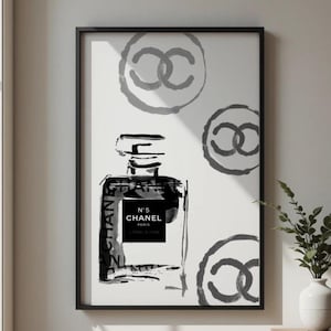 Peut inclure: Impression d'art encadrée en noir et blanc représentant une illustration de flacon de parfum. L'œuvre comprend le texte "N°5 CHANEL PARIS" et le logo Chanel. Le fond présente trois cercles gris du logo Chanel.