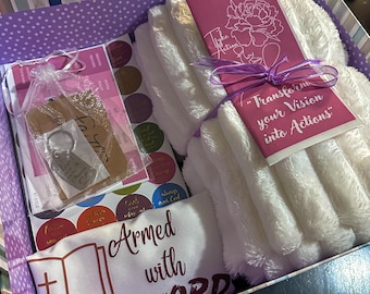 May include: A gift box with a purple and white polka dot design, filled with various items. Includes a white plush item, stickers, a keychain, and a card with the text "Transform your Vision into Actions". A pillow with the text "Armed with the WORD" is also visible.