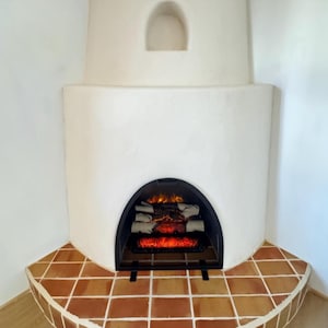 Puede incluir: Una chimenea blanca con un inserto de chimenea eléctrica negro. La chimenea está rodeada de azulejos de terracota.