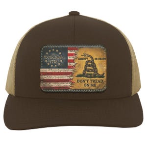 May include: A brown baseball cap with a tan mesh back and a rectangular patch on the front. The patch features a split design showing a United States flag with the text We The People 1776 and a Gadsden flag with a coiled snake and the text DON'T TREAD ON ME.