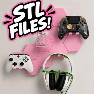 May include: A set of pink hexagonal wall-mounted display shelves holding a black and gold game controller, a white game controller, and white gaming headphones. The text STL FILES! is displayed in white with a thick pink outline in the upper left.
