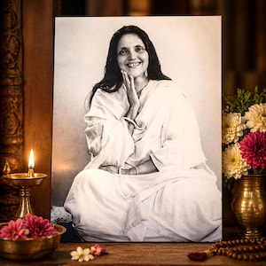 May include: A monochrome portrait of a woman in white attire, smiling and seated with hands near her face. A lit candle, flowers, and a vase are in the foreground. The background is blurred, creating a serene atmosphere.