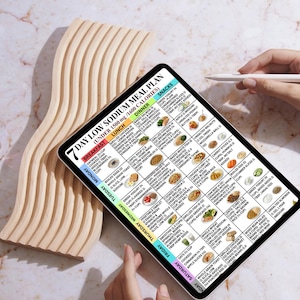 May include: A digital tablet displays a 7-day low sodium meal plan with breakfast, lunch, dinner, and snack options. The plan includes various food items and calorie counts. A wooden decorative piece is on the left.