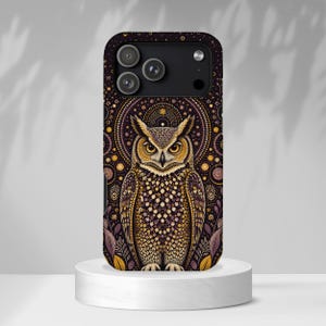 May include: A smartphone case featuring a detailed illustration of an owl with yellow eyes, centered against a dark background with intricate gold and purple circular patterns, geometric dots, and stylized leaf motifs surrounding the bird.