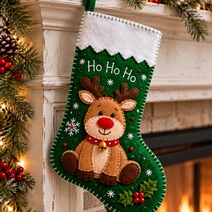 May include: A green felt Christmas stocking featuring a white cuff, a brown reindeer with a red nose and a small gold bell, and the embroidered text Ho Ho Ho. The stocking is decorated with white snowflake accents and red holly berries.