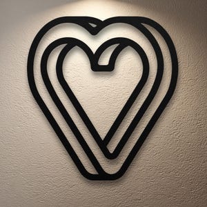 May include: Black heart-shaped wall art with a layered design. The artwork features three concentric heart outlines, creating a three-dimensional effect. The piece is mounted on a textured, off-white wall, and is illuminated by a soft light.
