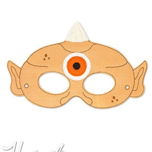 May include: A felt mask for kids with a single orange eye and a brown horn on top. The mask is designed to look like a cyclops.