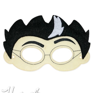May include: A felt mask of a boy with black hair, glasses, and a white streak in his hair. The mask is designed for a child to wear.