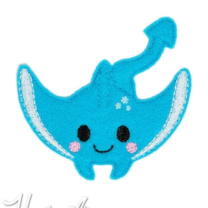 May include: A blue felt applique of a cartoon stingray with a smiling face, black eyes, and pink cheeks. The stingray has a white outline and a white tail.
