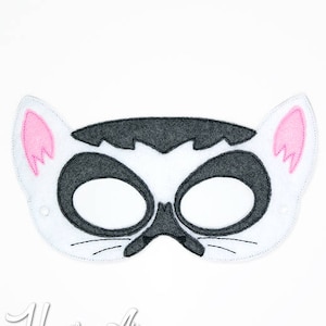 May include: A white felt mask with black and gray details, resembling a lemur. The mask has pink ears and eye holes.